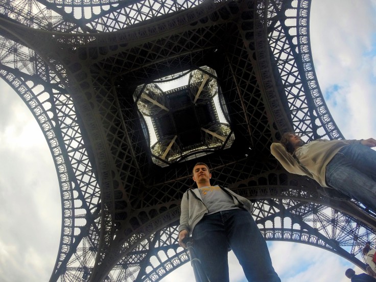 Two friends stand underneath the Eiffel Tower